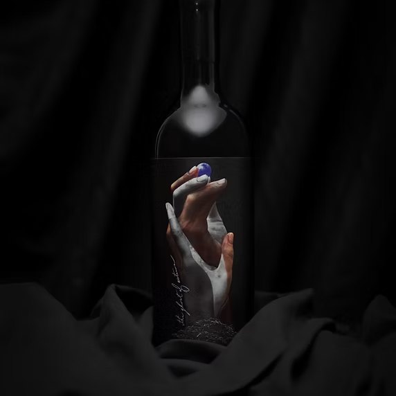 A bottle of the 2016 Single Vineyard Diamond Mountain Cabernet Sauvignon, its label showing a hand raised from dark earth holding a blue marble.